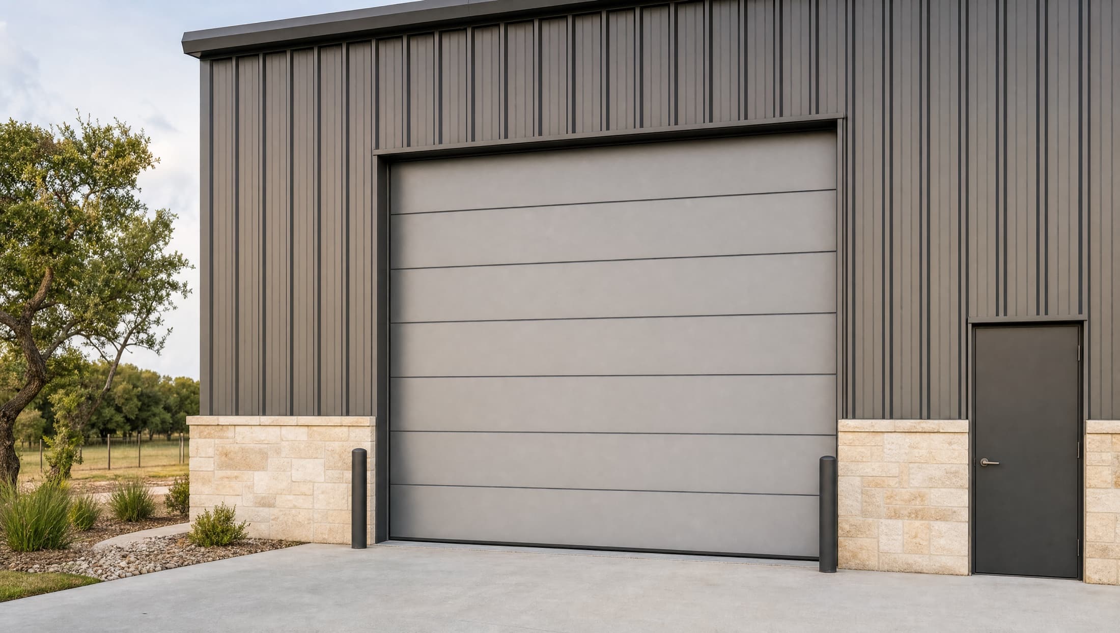Insulated commercial sectional overhead door on a Central Texas metal workshop